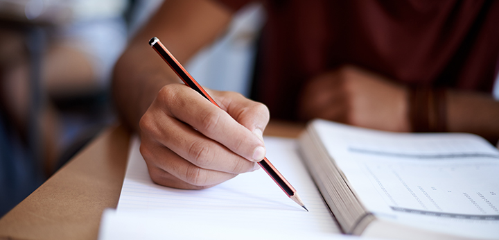 Student writing in book